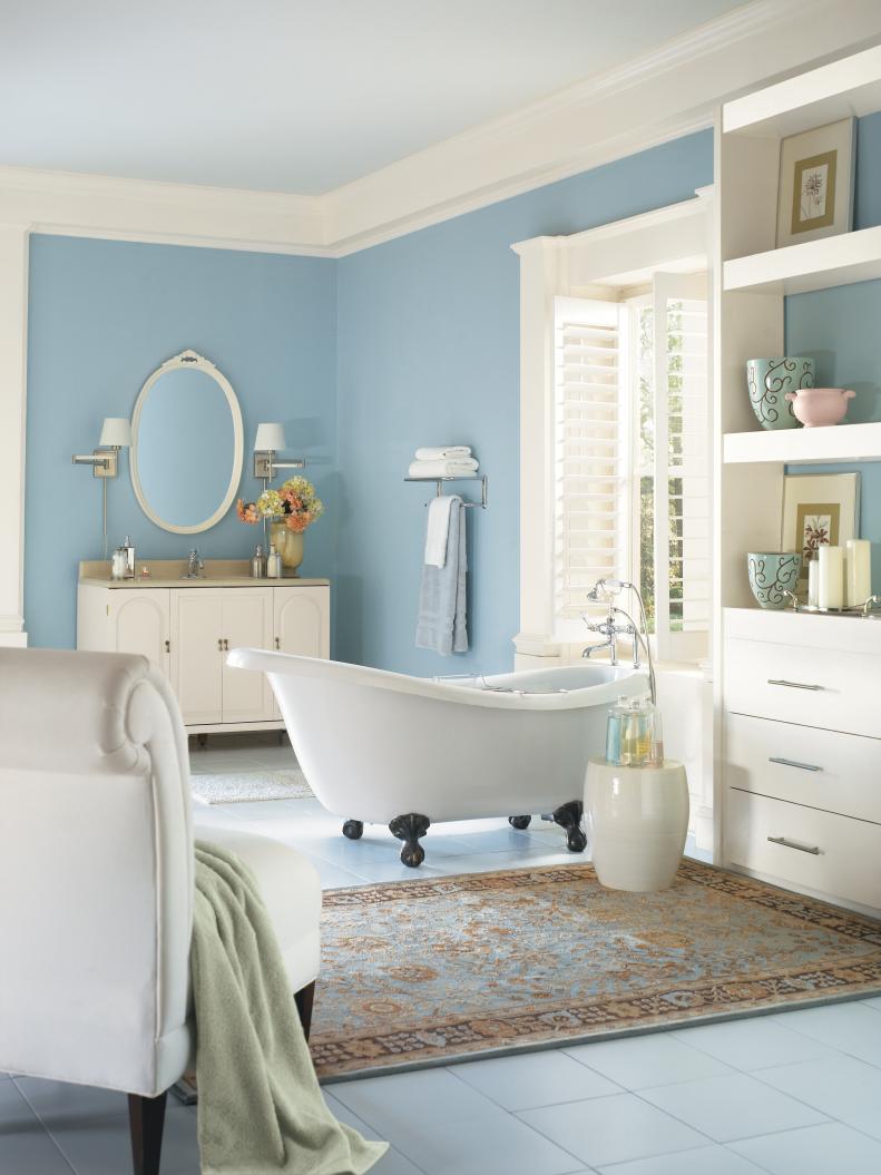Light Blue Bathroom With White Vanity, Shelf, Window & Slipper Tub