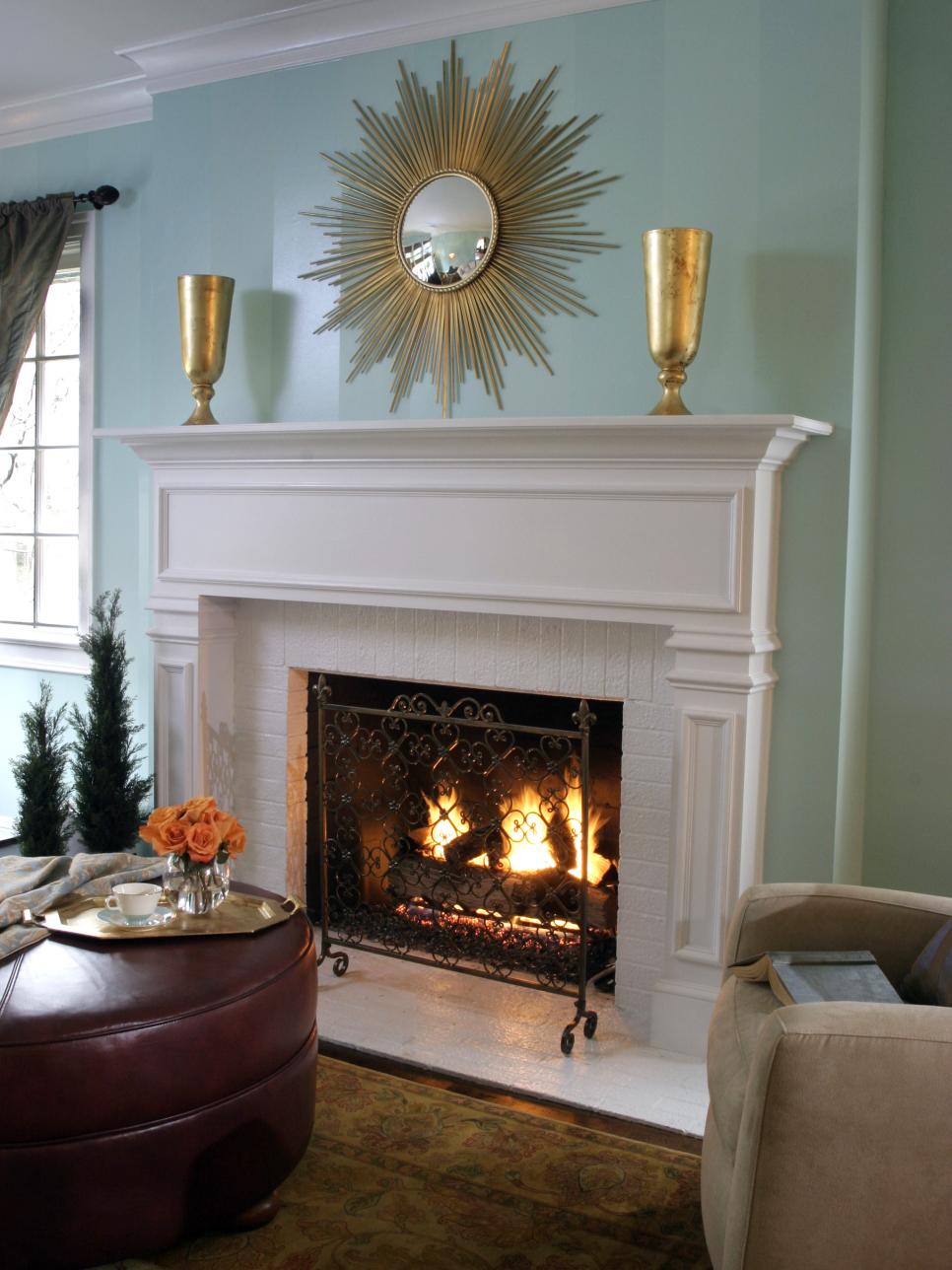 White Brick Fireplace in a Aqua Living Area With Gold Starburst Mirror