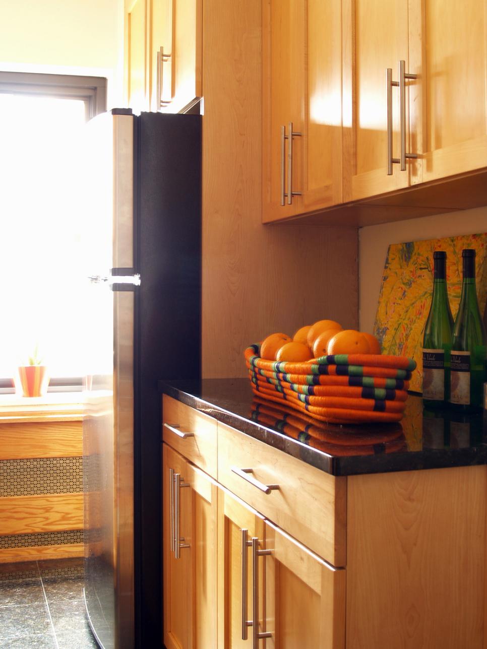 Light Wood Kitchen Cabinets With Sleek Hardware & Black Countertop