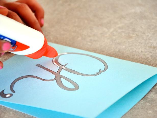 To add the glitter, place glue inside your script work on the front of your card. Cover the glue with glitter and let dry.