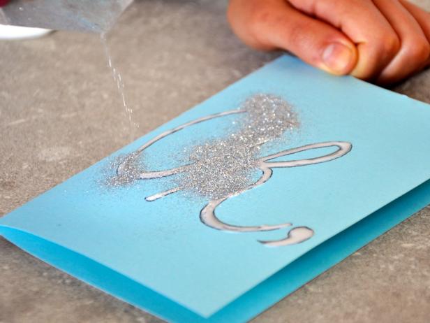 Make your script on the front and place glue on top. Shake glitter all over area. Allow glue to dry, then shake off excess glitter before placing card in envelope.