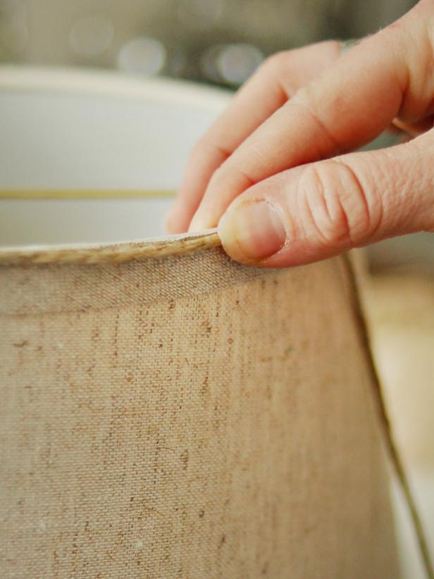 Hold in place until glue cools. Wrap until top trim of shade is covered and cut with scissors. Repeat process on bottom trim of shade. Tip: Alternately, the entire shade can be wrapped in twine, if desired. However, this may cause the lamp's illumination to be dimmer.