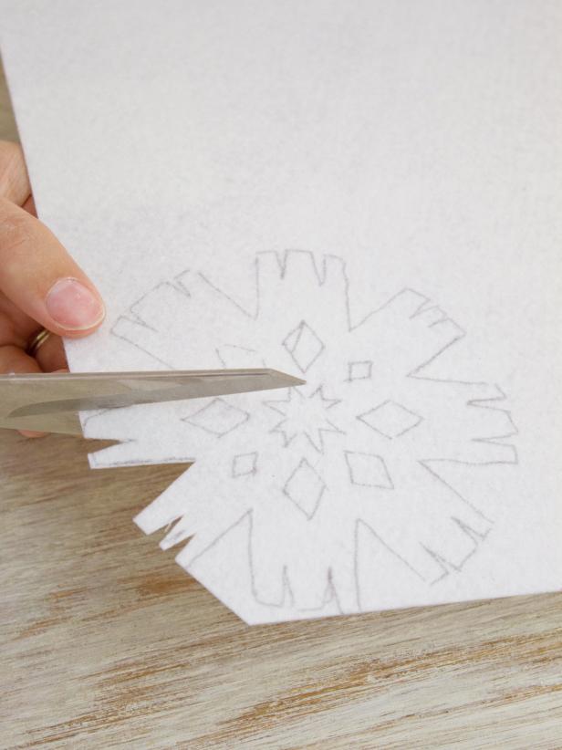 Carefully cut out felt snowflakes using scissors and a craft knife.