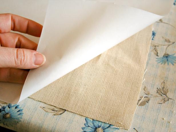 Place one piece of linen face down on ironing board. Put the plastic coating of the freezer paper face down onto linen.