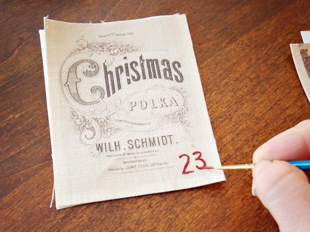 Use a 1.0 liner brush to paint numbers 1-25 in the corner of each pocket. Allow paint to dry. Tip: Sketch numbers lightly with a pencil prior to painting.