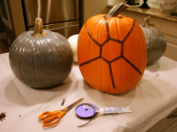 While painted pumpkins dry, cut lengths of black ribbon and attach to unpainted pumpkin with glue in a spider web pattern.