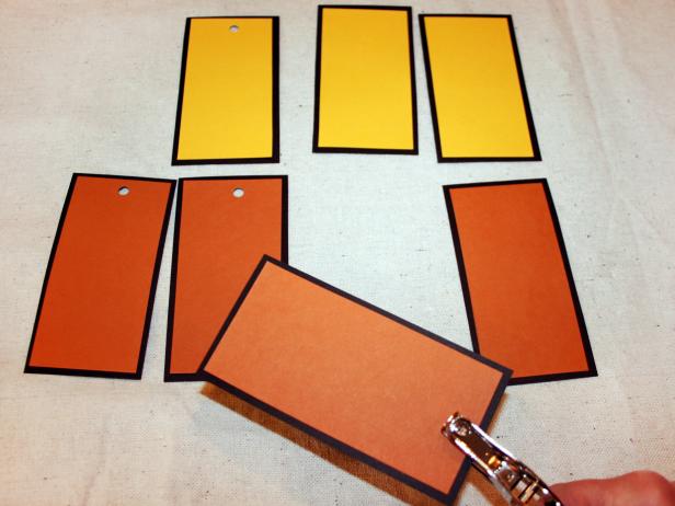 Punch holes in your paper tags. Later, you will thread ribbon through these holes.
