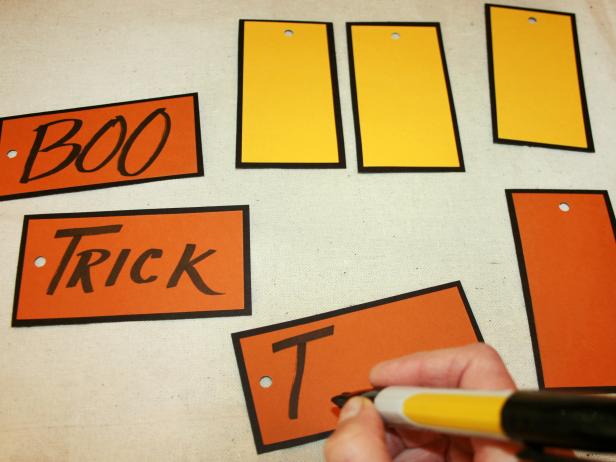 Write Halloween phrases on tags with wide-tip black marker you'd like to hang from your centerpiece.
