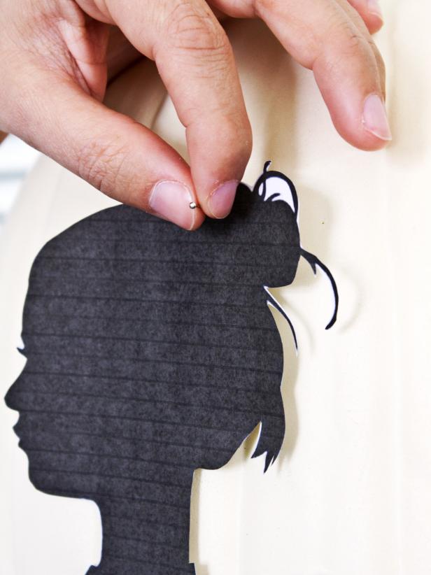 Temporarily attach the silhouette to the pumpkin with stick pins.