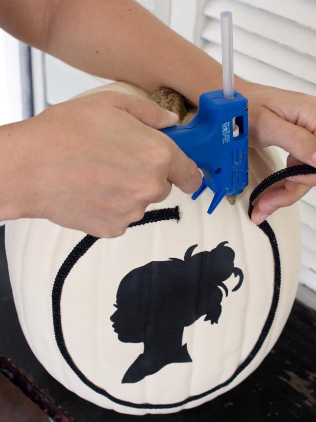 Hot glue the black trimming onto your pumpkin in the shape of a circle.