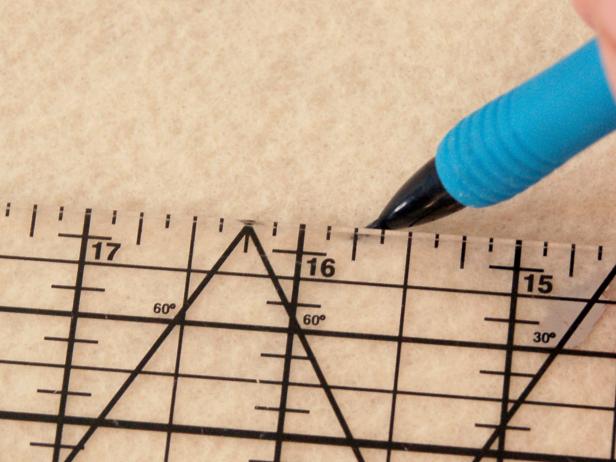 To make a spooky Halloween applique pillow, start by measuring and marking felt.