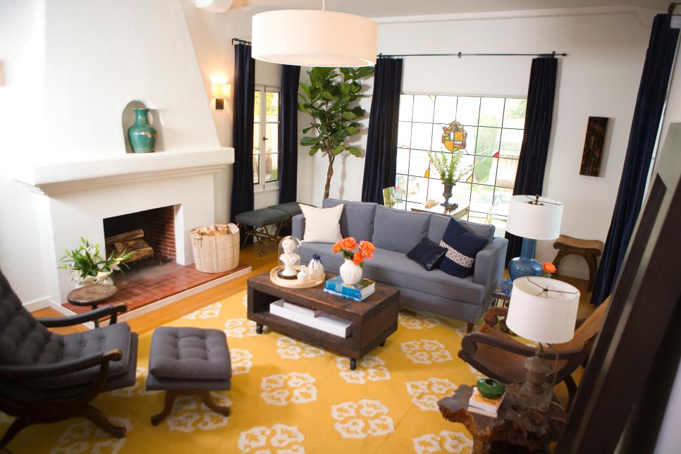 White Living Room With Fireplace, Yellow Rug, Navy Drapes + Gray Sofa
