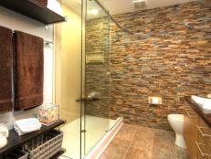Bathroom With Stacked Stone Wall, Shelf Storage and Glass Shower