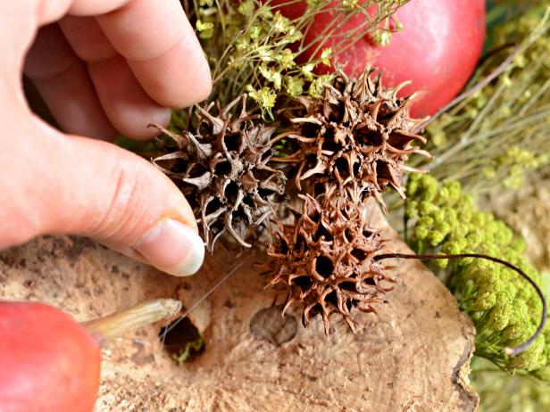 Once main elements of wreath are affixed, use hot glue to fill in sparse areas with clumps of moss, small pinecones or seed pods