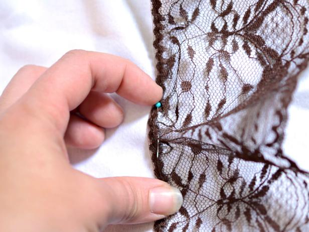 Wash and iron tablecloth. Place lace trim around bottom edge of tablecloth and pin into place.