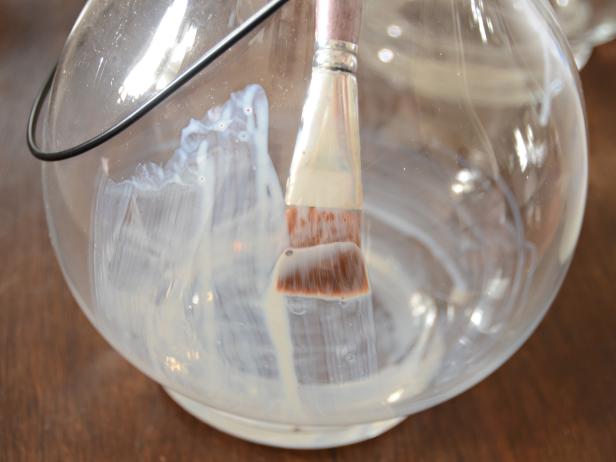Clean and dry glass. Using a one-inch artists' brush, apply a thin layer of leaf adhesive to inside of hurricane (Images 1 and 2). Allow to dry until adhesive is clear and tacky (Image 3). Tip: To eliminate possible drips or pooling, gently brush over adhesive after about 10 minutes of drying time to create a smooth surface.