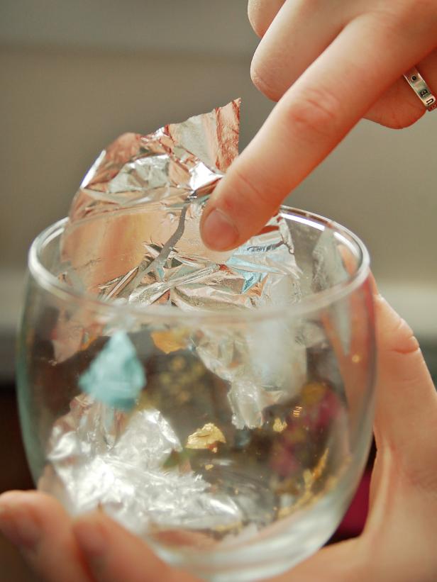 Full sheets of silver leaf are applied to the interior of this glass votive.