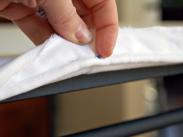 Turn cotton twill fitted to table inside out and pin piping along bottom edge of table. Make sure raw edges are facing same direction.