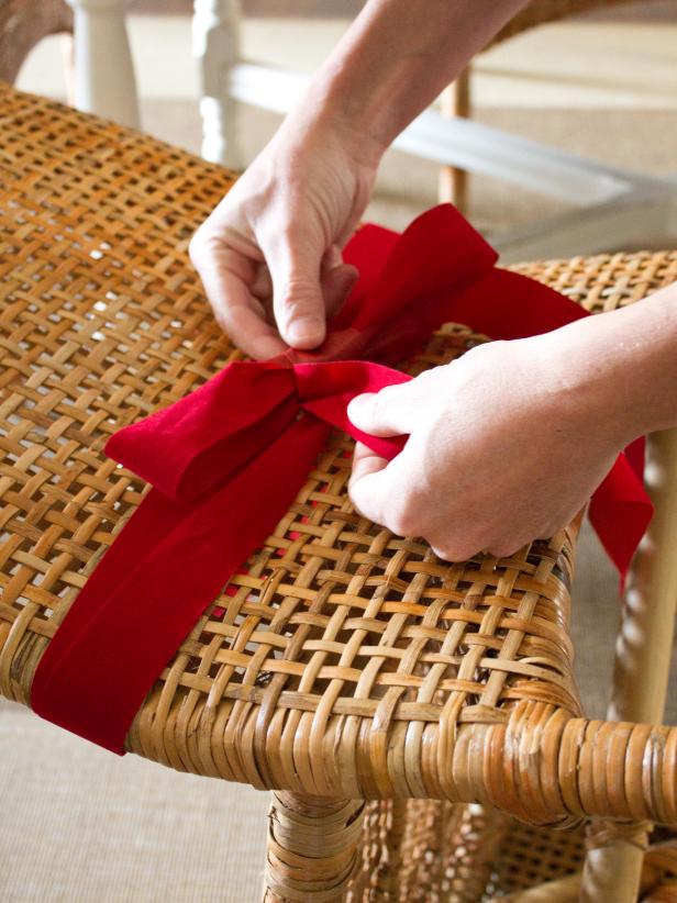 Tie a simple two-loop bow in the center of each chair. Tip: Turn the chair on its front to create a more stable and accessible work surface.