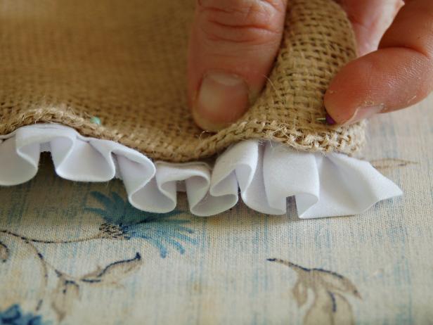 After cutting pleated trim to the exact width of runner, insert trim into open end and pin in place.