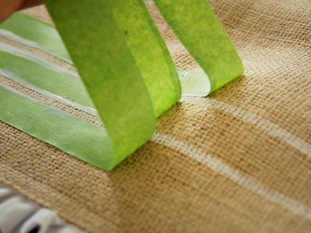 Use a dry-brush technique to prevent paint from bleeding under tape. To dry-brush, load paint onto brush and blot on paper towel to remove most of the paint. Remove tape immediately.
