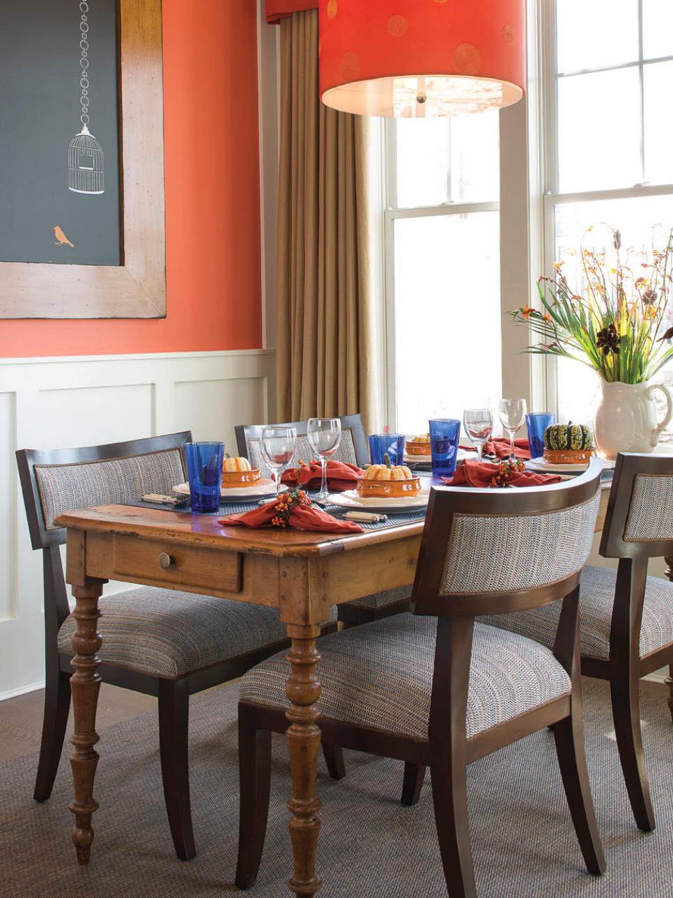 Traditional Dining Room With Burnt Orange Walls and Light Fixture