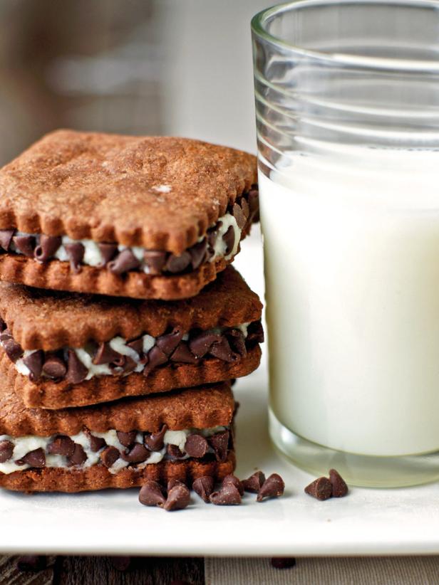 Brown Cookies With Creamy Filling, Chocolate Chips and Glass of Milk