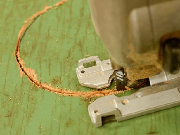 Put jigsaw blade inside drilled hole and cut along marked line. Sand edges to smooth. Repeat with other holes.