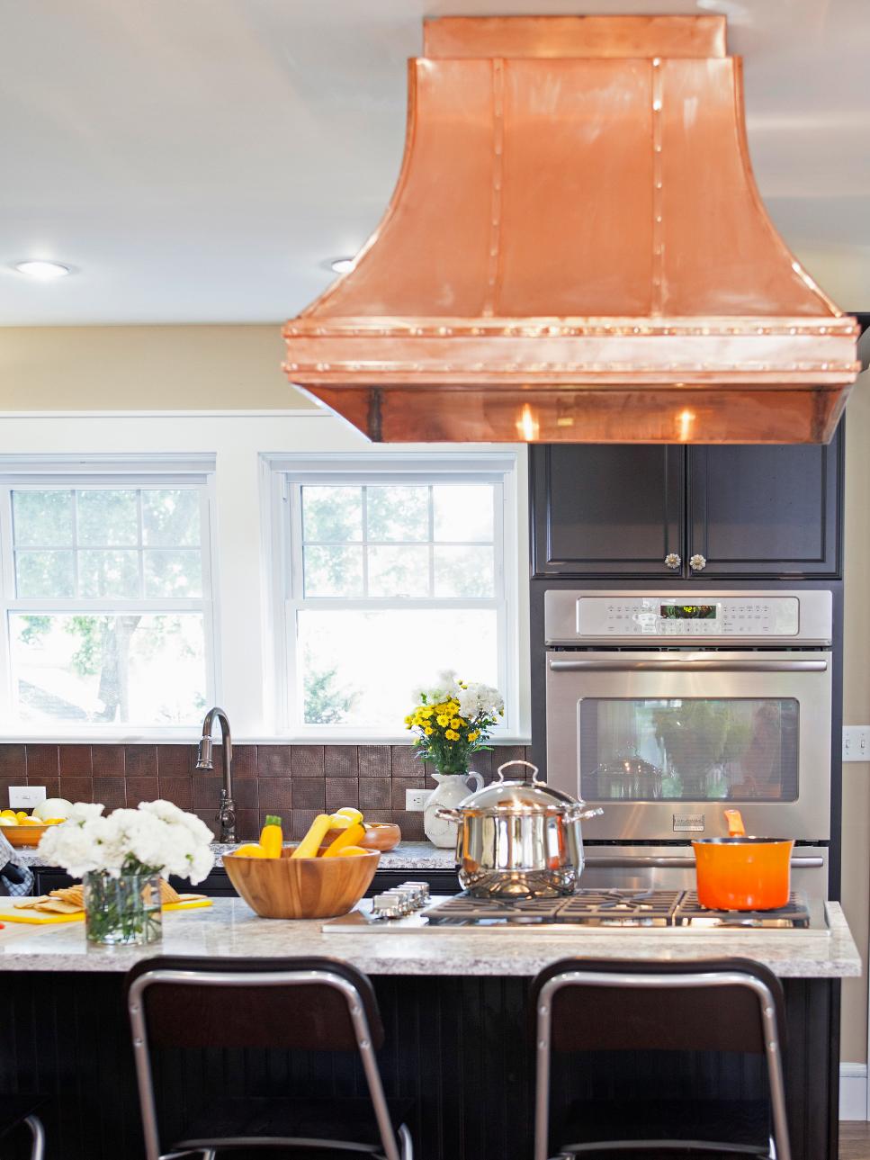 Neutral Traditional Kitchen With Black Cabinetry and Copper Range Hood