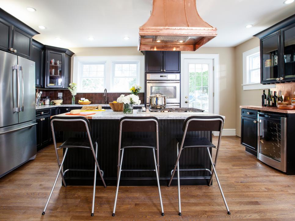 Kitchen With Copper Range Hood, Black Island and Black Cabinetry