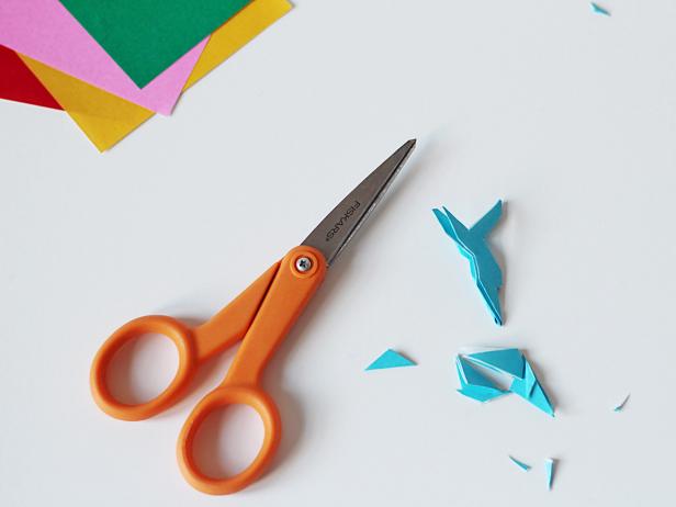Fold a sheet of paper into a triangle. Then, fold that triangle into a smaller triangle. Fold each side point into the middle. Cut off the points. You now have a triangle-shaped piece that’s ready to fashion into a snowflake.