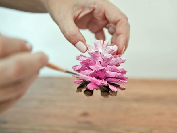 To create an ombre-painted pinecone, starting at the top of the pinecone with the lightest shade, paint the top few rows of petals. Paint the middle of the pinecone with the medium shade, and the bottom of the pinecone with the darkest shade.