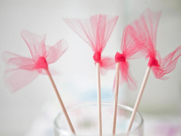 It's the fun details that make a party memorable. These tulle cocktail stirrers do just that! Purchase a yard of brightly-colored tulle at your local fabric store. Cut it into 1-inch strips. Tie the strips around the top of plain, wooden stirrers. Glue into place at the very top of the stick.