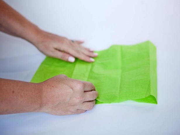 Fold tissue paper four times to create a beautiful fringed bow.