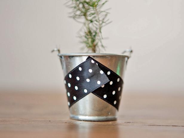Cut a length of ribbon that just wraps around the stainless steel bucket. Add a dab of hot glue in the center of the bucket. Wrap the ribbon around the bucket and hot glue the remaining end.