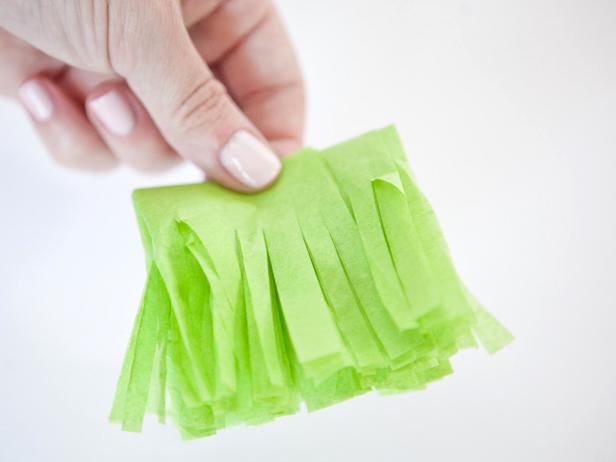 Cut slits 1/4-inch apart across the loose end of the folded tissue paper. Cut to 1/2-inch from the fold. The tissue paper will look like fringe.