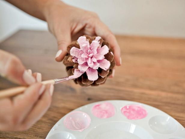 To create an ombre-painted pinecone, starting at the top of the pinecone with the lightest shade, paint the top few rows of petals. Paint the middle of the pinecone with the medium shade, and the bottom of the pinecone with the darkest shade.