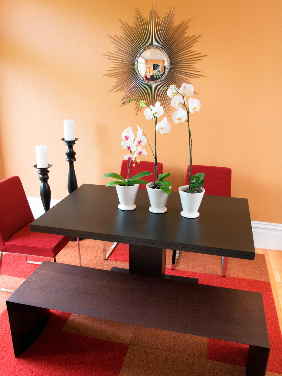 Modern Orange and Red Dining Room With Starburst Mirror