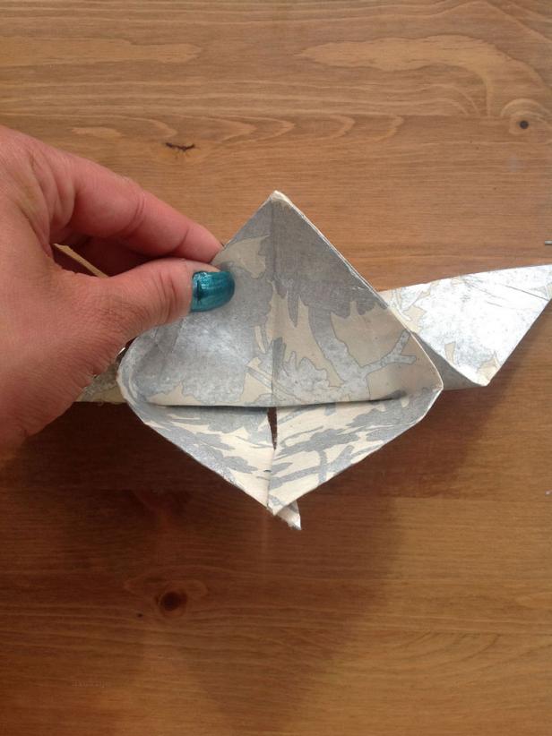 Turn the paper over. Fold the corner past the edge about half an inch.