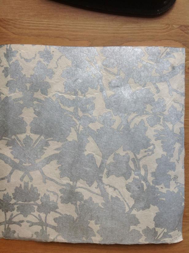 Place paper wrong side up on a flat working surface. Fold the paper in half aligning top and bottom edges neatly. Run along fold to get a crease.