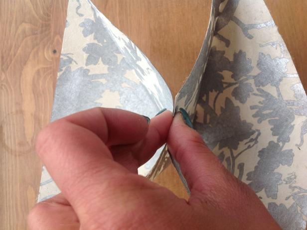 Unfold your paper. Using your finger, push the middle down so it pops in.