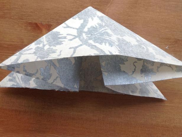 Bring the left and right horizontal creases together and collapse into a triangle.