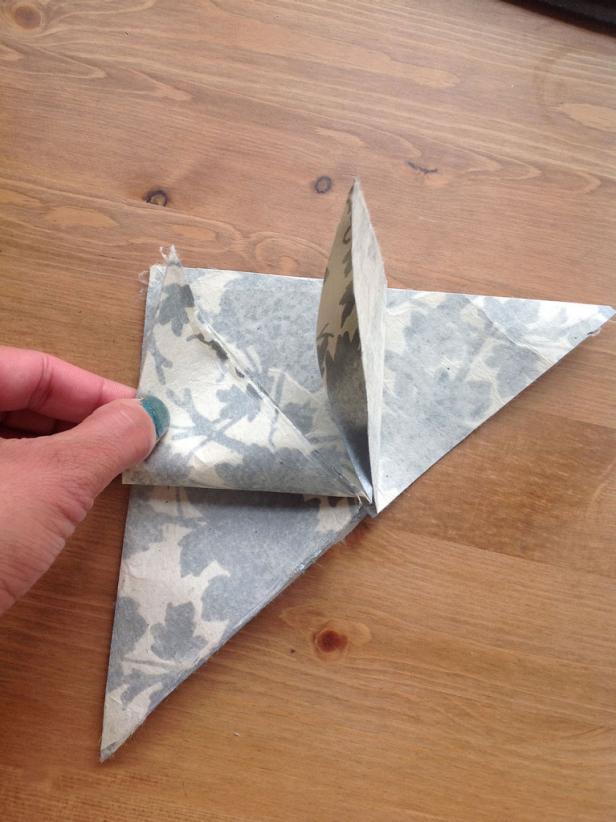 Fold the left corner of the top layer to the top corner of the triangle.