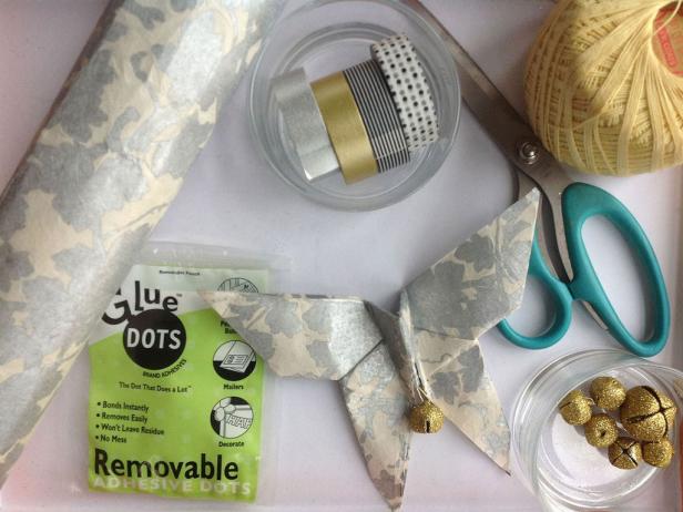 Assemble all the craft materials together before you begin like paper, string, washi tape, beads, bells, glue dots and scissors.