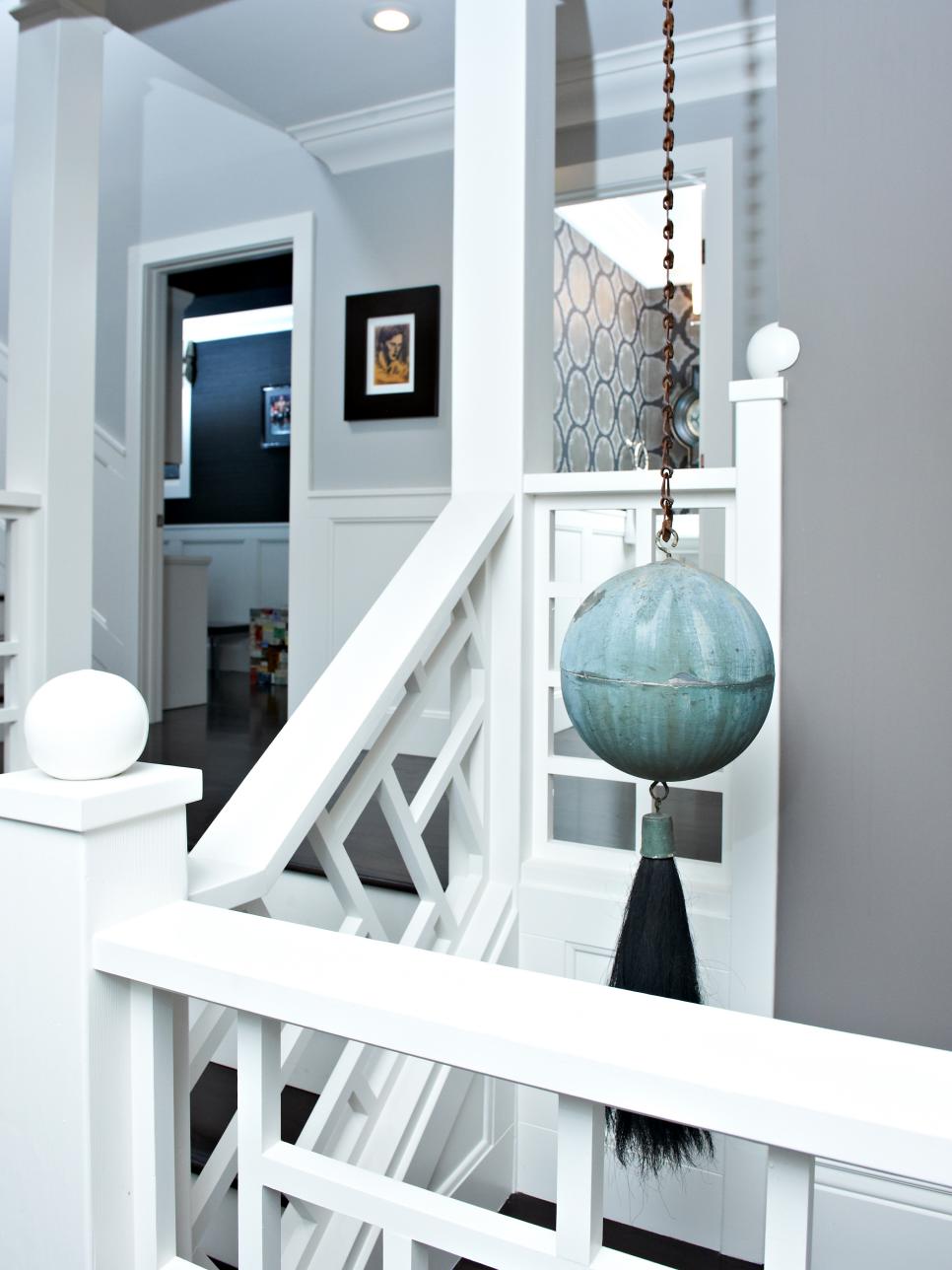 Gray and White Stairway With Geometrical Woodwork and Hanging Art