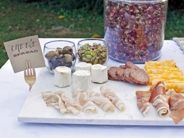 A cheese plate makes ideal picnic food: It doesn't require cooking and it's bound to please a crowd. Present a mix of your favorite meats, cheeses and olives atop a marble board. Create your own food-tag holders by spray-painting discount metal forks and folding them into a "U" shape.