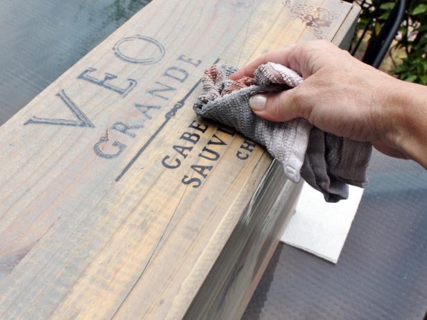 Rag Wiping Away Excess Stain From Wood Crate