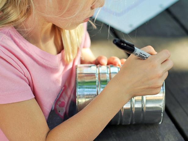 First, draw your design on paper. Then draw your design in dots on the can using a Sharpie.