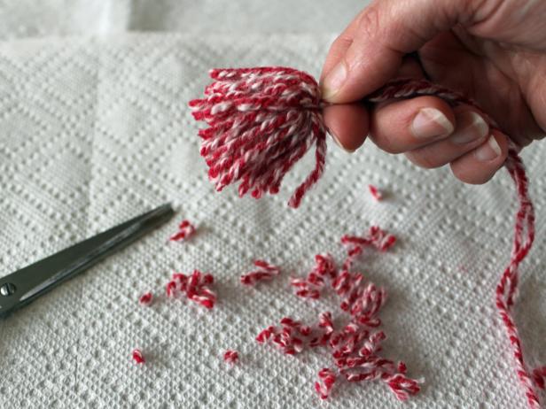 Clean up any longer ends of yarn and give your finished pom-pom a more rounded shape by trimming it.