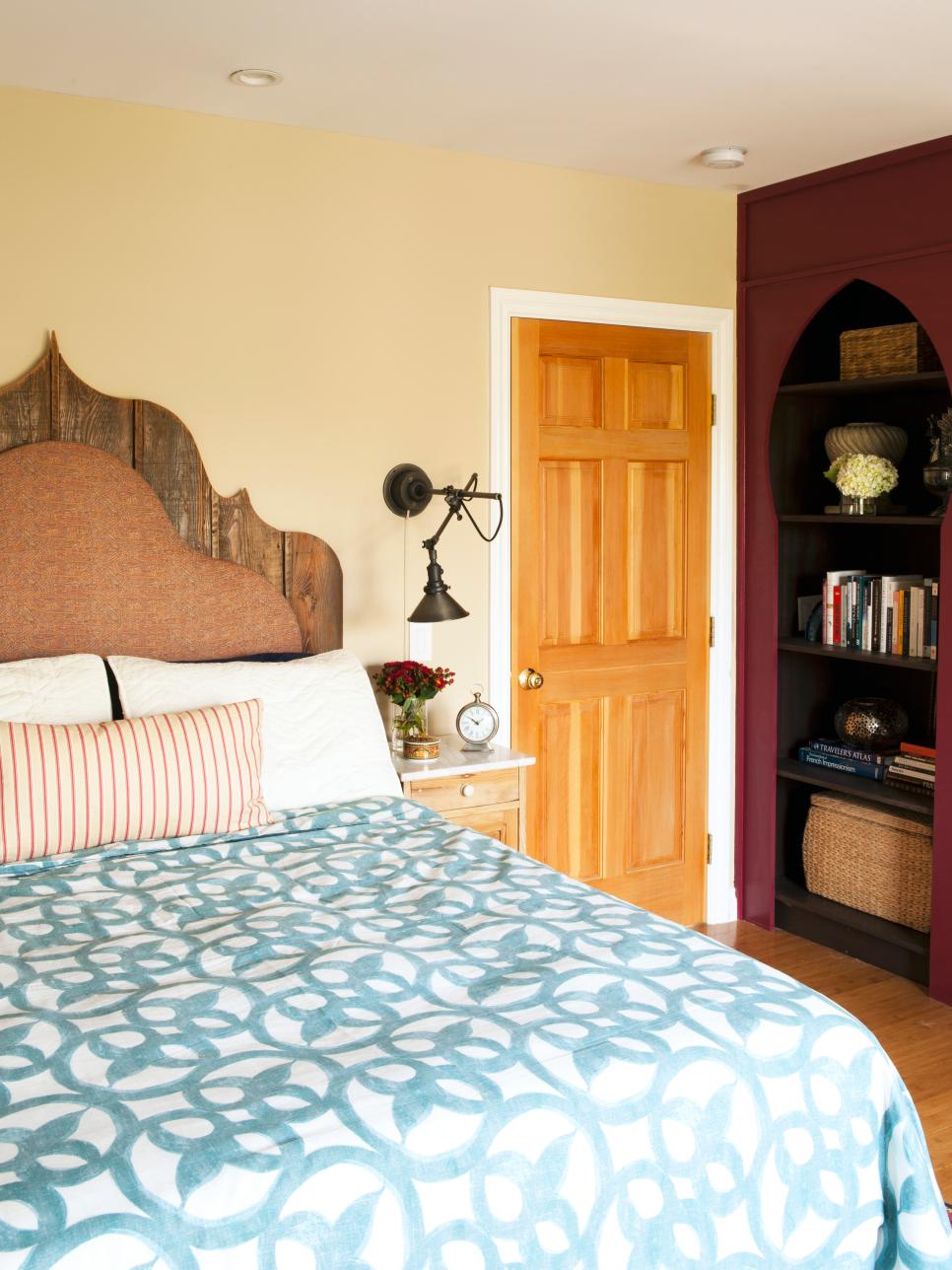 Eclectic Bedroom With Industrial Wall Lamp Neutral Bedroom With Upholstered Wood Headboard, Wall Lamp & Bookcase